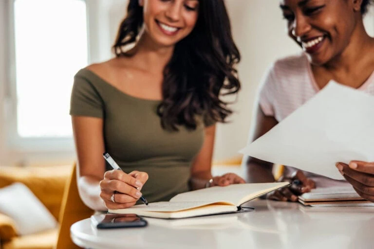 Two women working and conversing
